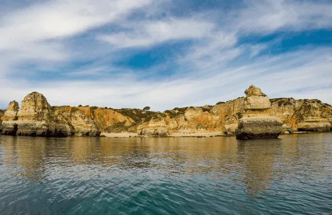 cliffs water sky clouds